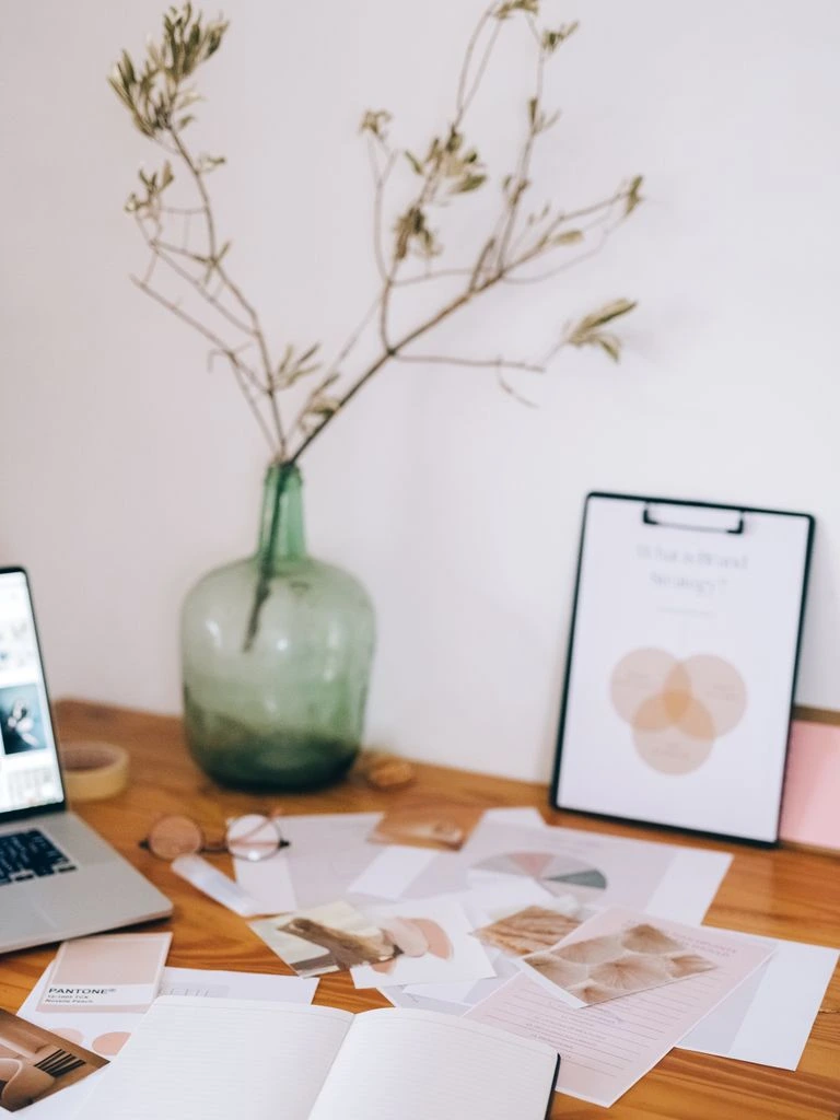A still life of coffee, paper, and afternoon light on a wooden desk